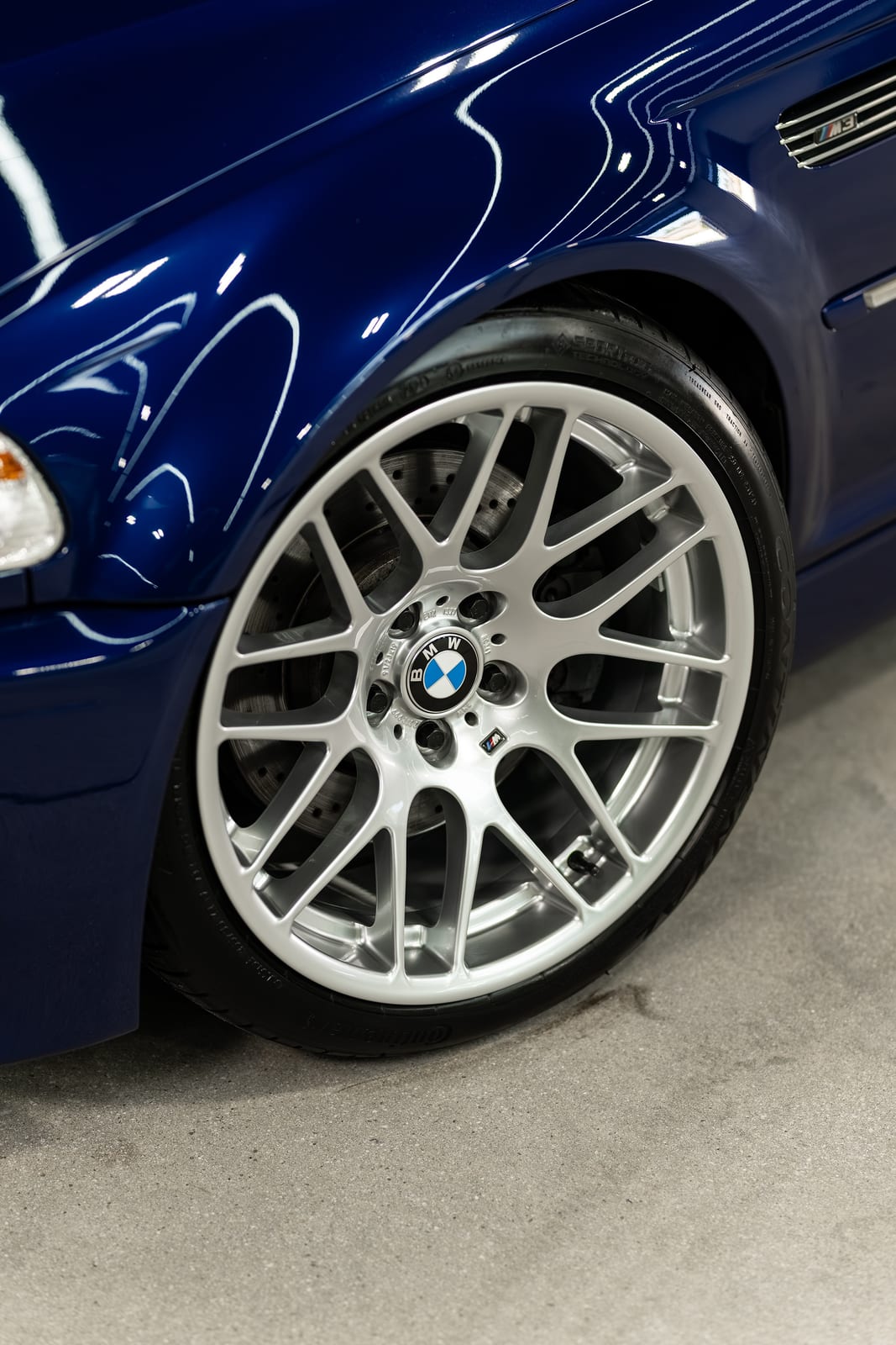 Close-up of a blue BMW M3 wheel and fender