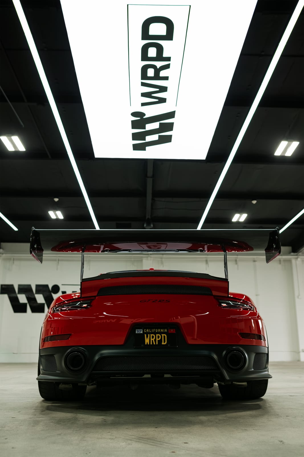 Rear of a red Porsche GT2 RS with carbon wing at WRPD in Chatsworth