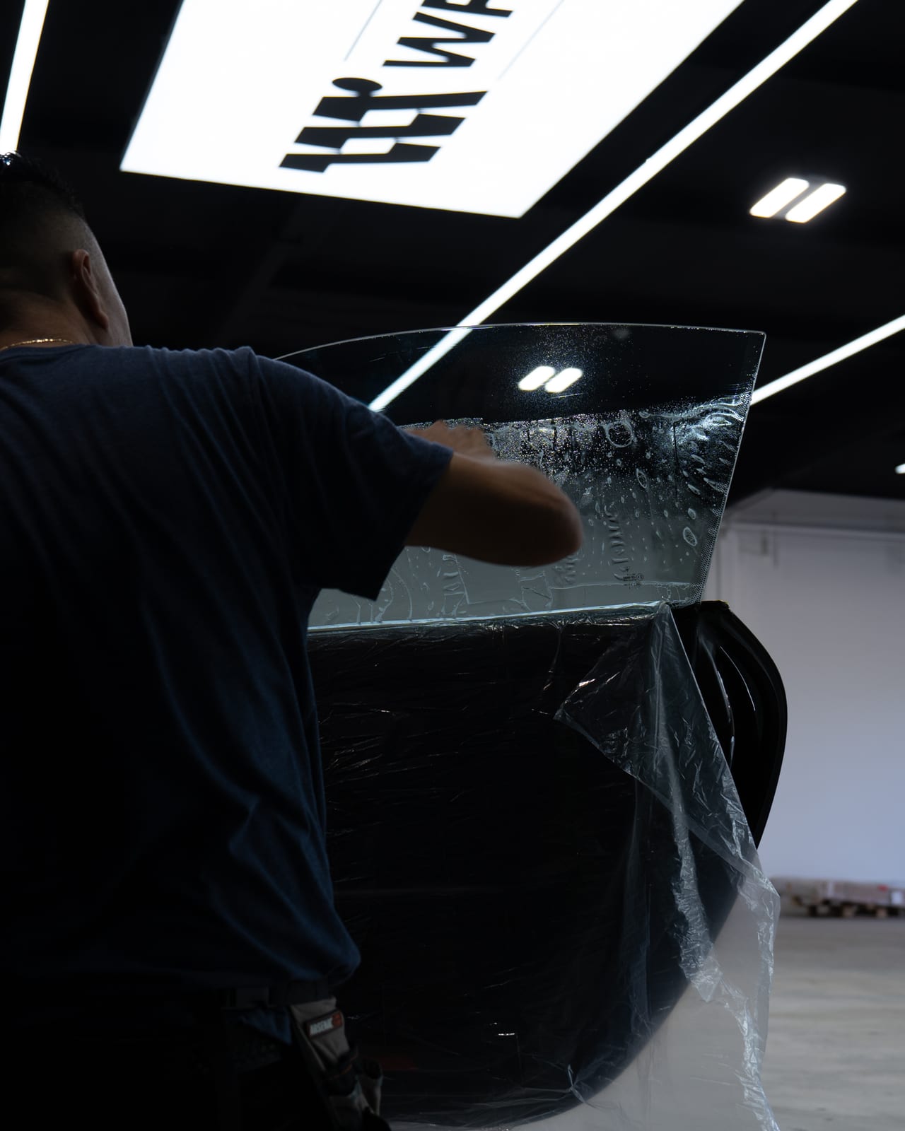 WRPD installer fitting window film under the WRPD sign at the Chatsworth studio